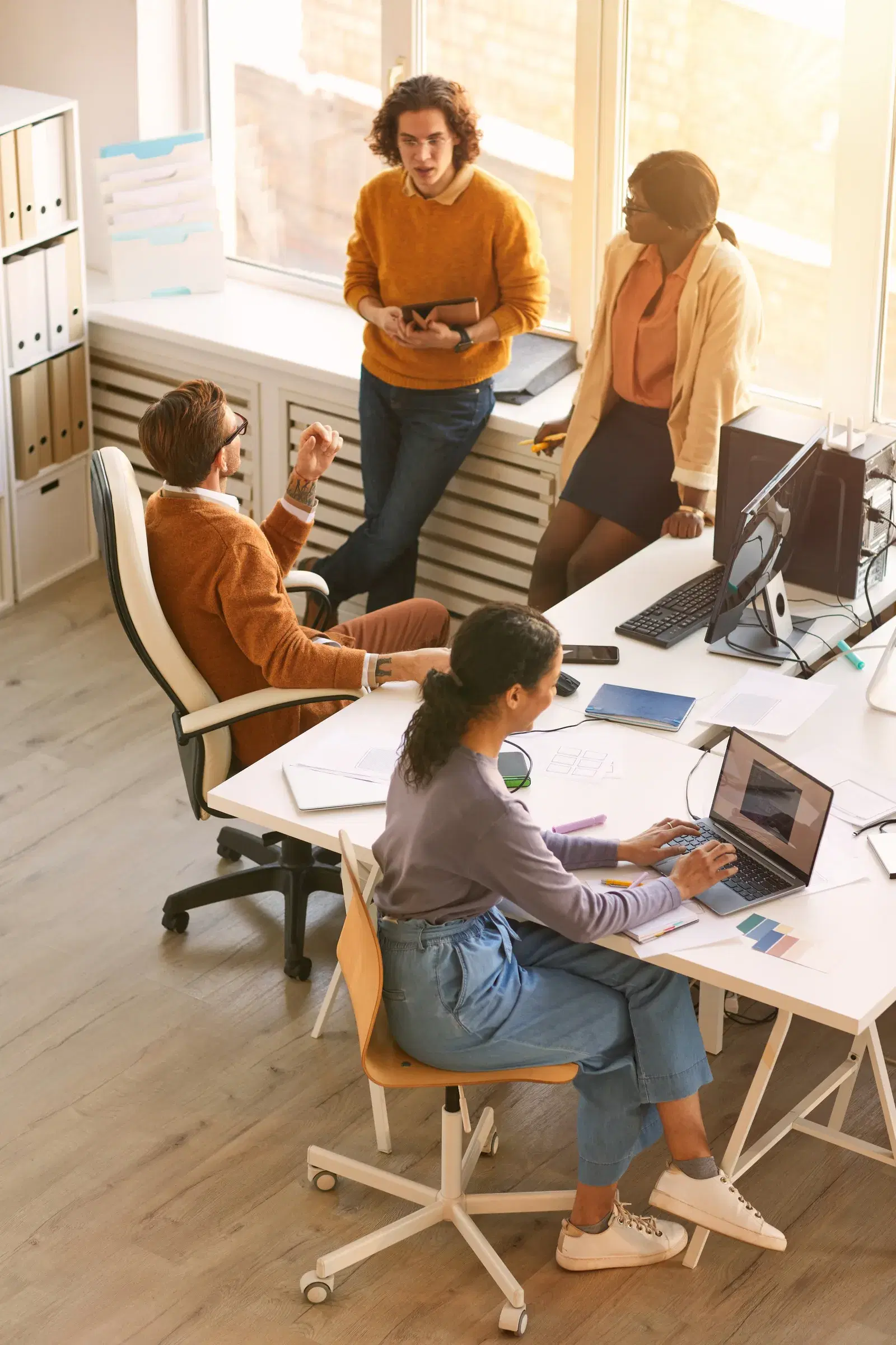 Insurance teammates collaborating around a desk in an open office